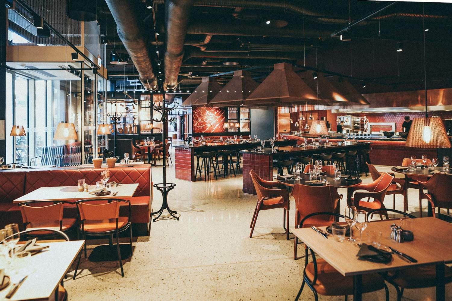 Warm, modern restaurant interior with an open kitchen